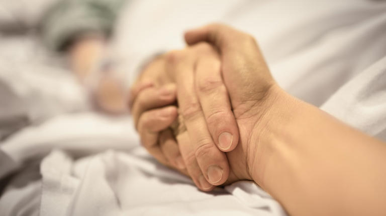 Family member holding hand of patient